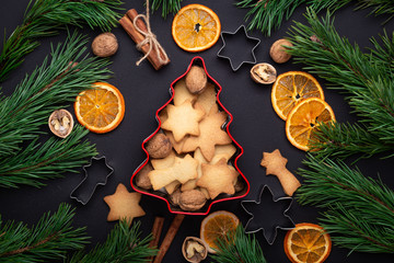 Homemade fresh cookies in a tin box Fir branches Dried slices of orange Cookie cutters