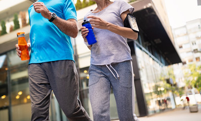 Obraz premium Fitness, sport, people, exercising and lifestyle concept - senior couple running