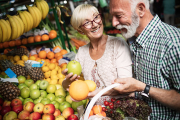 Senior shopping couple with basket on the market. Healthy diet.
