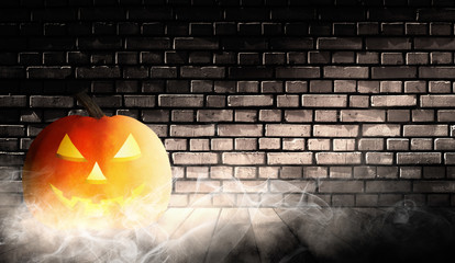 Halloween background. Festive pumpkin head on the background of an old brick wall, smoke, fog, rays...