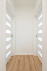 Hallway with white closed doors in apartment