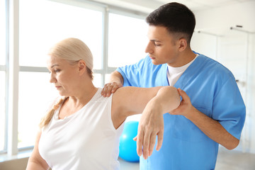 Obraz premium Physiotherapist working with mature patient in rehabilitation center