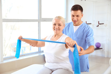 Obraz premium Physiotherapist working with mature patient in rehabilitation center
