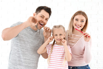 Family cleaning teeth on white background