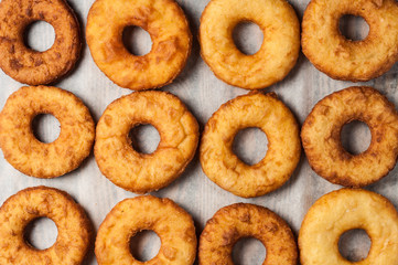 Lot of homemade baked donuts without cream lies on paper and old rustic wooden table