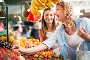 Young women shopping on the market healthy vegetables and fruits