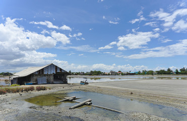 Old salt warehouse use to stock material located in salt farm in summer with clear blue sky and clouds