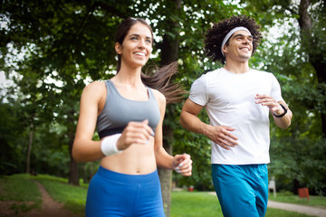 Happy young people jogging and exercising in nature