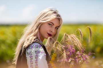 Beautiful girl in traditional costume in a wheat field