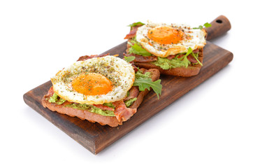 Board with tasty toasts on white background