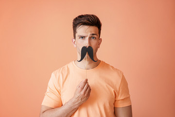 Funny portrait of handsome man with fake mustache on color background - Powered by Adobe