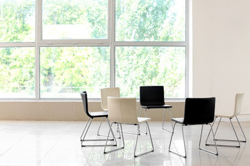 Empty chairs prepared for group therapy indoors