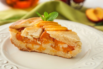 Piece of tasty peach pie on plate, closeup