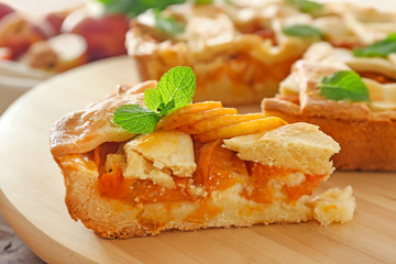 Piece of tasty peach pie on table