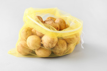 Eco bag with potato on light background