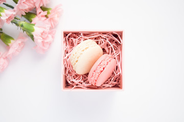 Beautiful carnation flowers and two macaroons in decorative box.