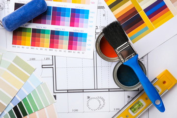 Cans of paint with supplies, palette samples and house plan