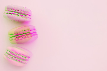 Glitch effect and desserts. Pink and green macaroons with glitch effect on a flat lay. Place for text. Horizontal image.