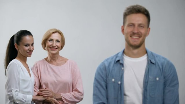 Woman and mother-in-law holding hands, admiring male in family, relations