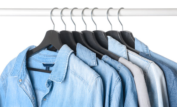 Rack with hanging clothes on white background