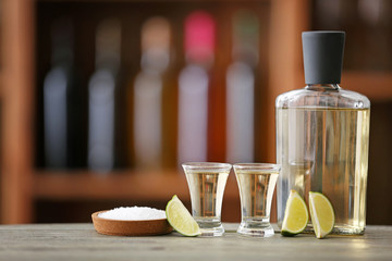 Tasty tequila with lime and salt on table in bar