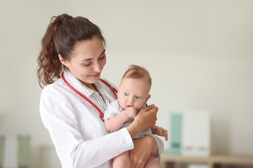 Pediatrician with cute little baby in clinic