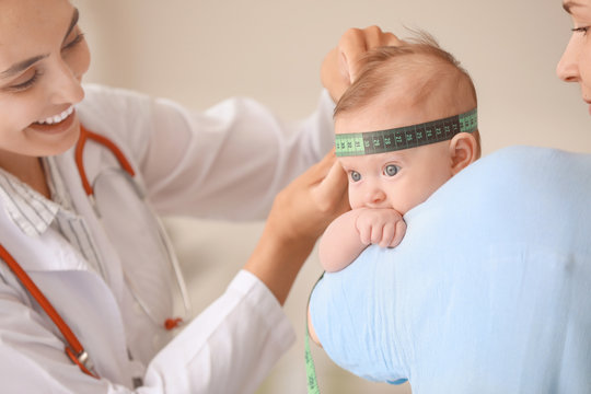 Pediatrician examining little baby in clinic