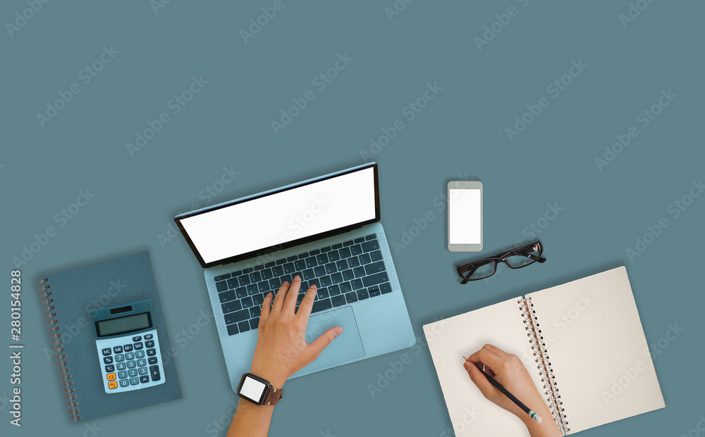 Poster a man is working by using a laptop computer on blue table. hands typing on a keyboard. top view.