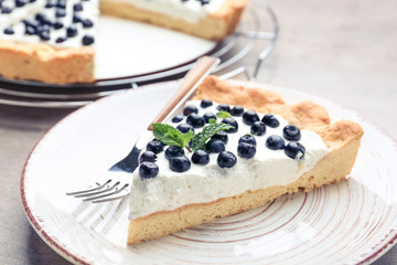 Plate with piece of tasty bilberry pie on table, closeup