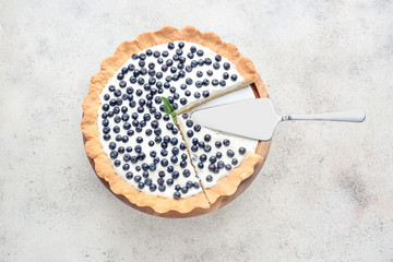 Tasty bilberry pie on grey background