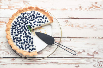 Tasty bilberry pie on wooden background