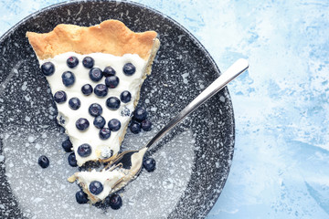 Plate with slice of tasty bilberry pie on color background