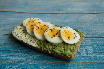 Sandwich with avocado paste, cottage cheese and sliced boiled egg