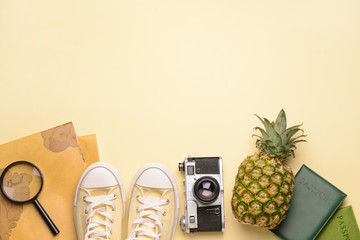 Composition with world map, shoes, photo camera, passports and pineapple on light background