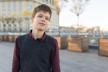 Outdoor portrait of smiling teenager boy 14, 15 years old