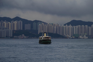 Star Ferry with apartment buildings of Yau Tong district and casino cruise ship in background with...