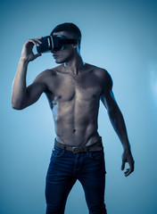 Fototapeta na wymiar Sexy strong african american man wearing VR headset exploring 3D new world