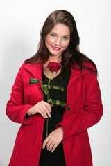 Jolie jeune femme habillée en rouge avec un rose pour la Saint Valentin