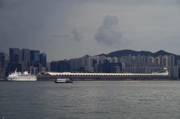 View of Kai Tak cruise terminal with classic casino cruise ship and Kowloon Bay skyline in...