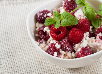 Sweet curd with raspberries, decorated with a sprig of mint.