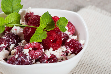 Sweet curd with raspberries, decorated with a sprig of mint.