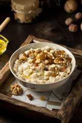 Oatmeal with nuts (hazelnuts, walnuts) and honey, porridge for Breakfast. Tasty, healthy food