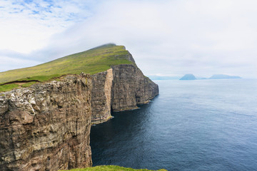 Faroese landscape panorama with rocks above the ocean. Vagar, Faroe Islands.