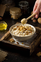 Oatmeal with nuts (hazelnuts, walnuts) and honey, porridge for Breakfast. Tasty, healthy food