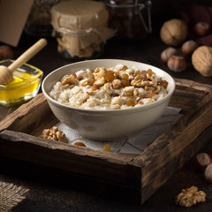 Oatmeal with nuts (hazelnuts, walnuts) and honey, porridge for Breakfast. Tasty, healthy food
