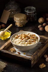 Oatmeal with nuts (hazelnuts, walnuts) and honey, porridge for Breakfast. Tasty, healthy food