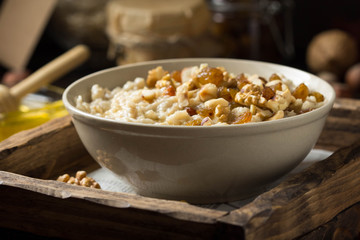 Oatmeal with nuts (hazelnuts, walnuts) and honey, porridge for Breakfast. Tasty, healthy food