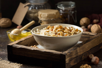 Oatmeal with nuts (hazelnuts, walnuts) and honey, porridge for Breakfast. Tasty, healthy food