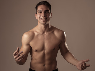 Portrait of strong handsome Athletic man feeling good and happy isolated on neutral background