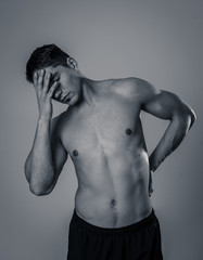 Naklejka premium Strong young man suffering lower back pain in stress and bad posture